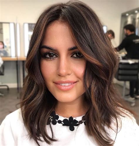 This layered cut displays a subtle dimension that shows off her highlights and has an enviable texture. . Shoulder length dark brown hair